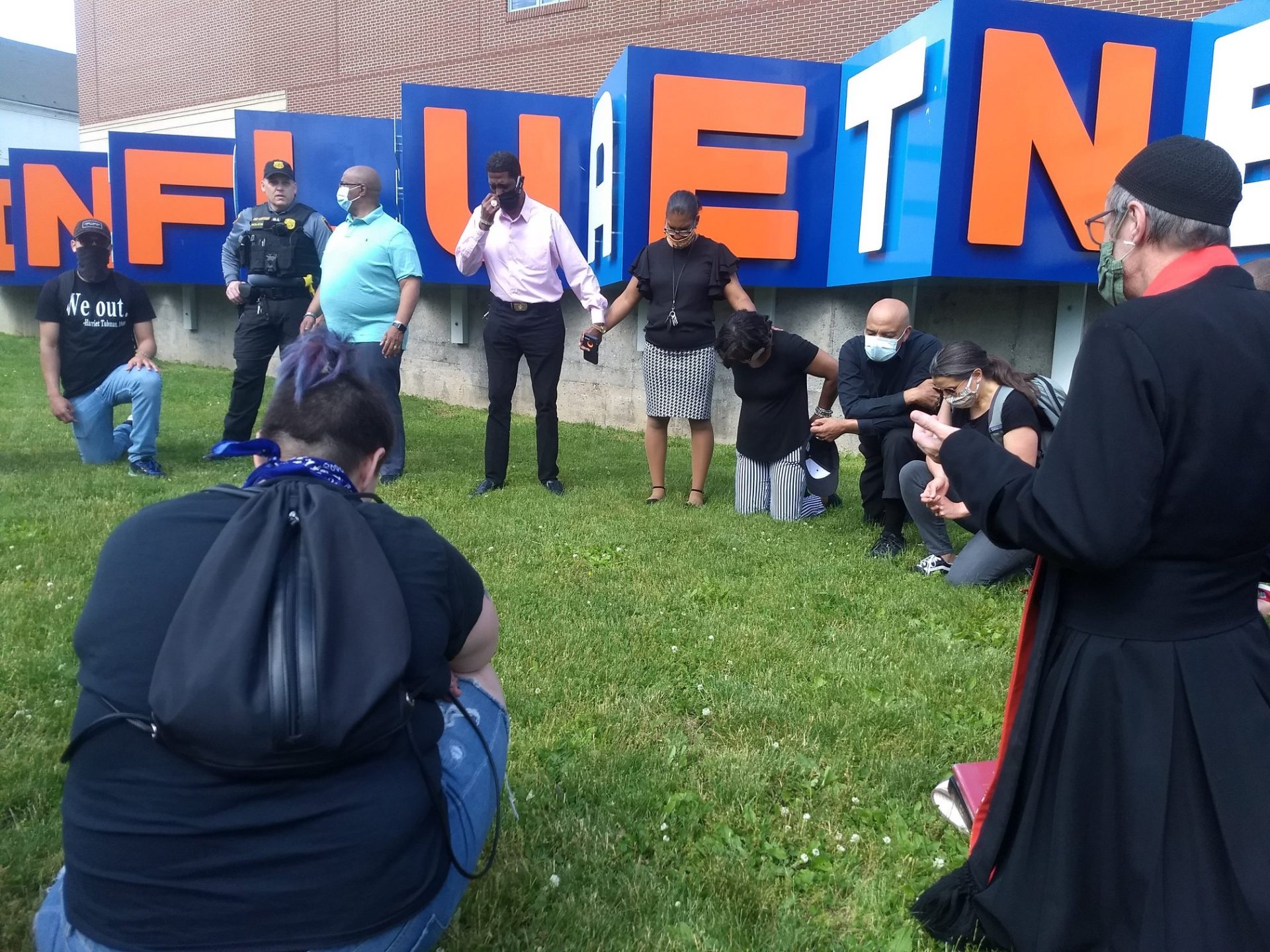 Community and faith leaders join hands for a prayer during protests at the corner of North Prince and West Chestnut streets in Lancaster on Sunday, May 31, 2020. Kneeling at right is Mayor Danene Sorace. (Photo: Todd Gusler) 