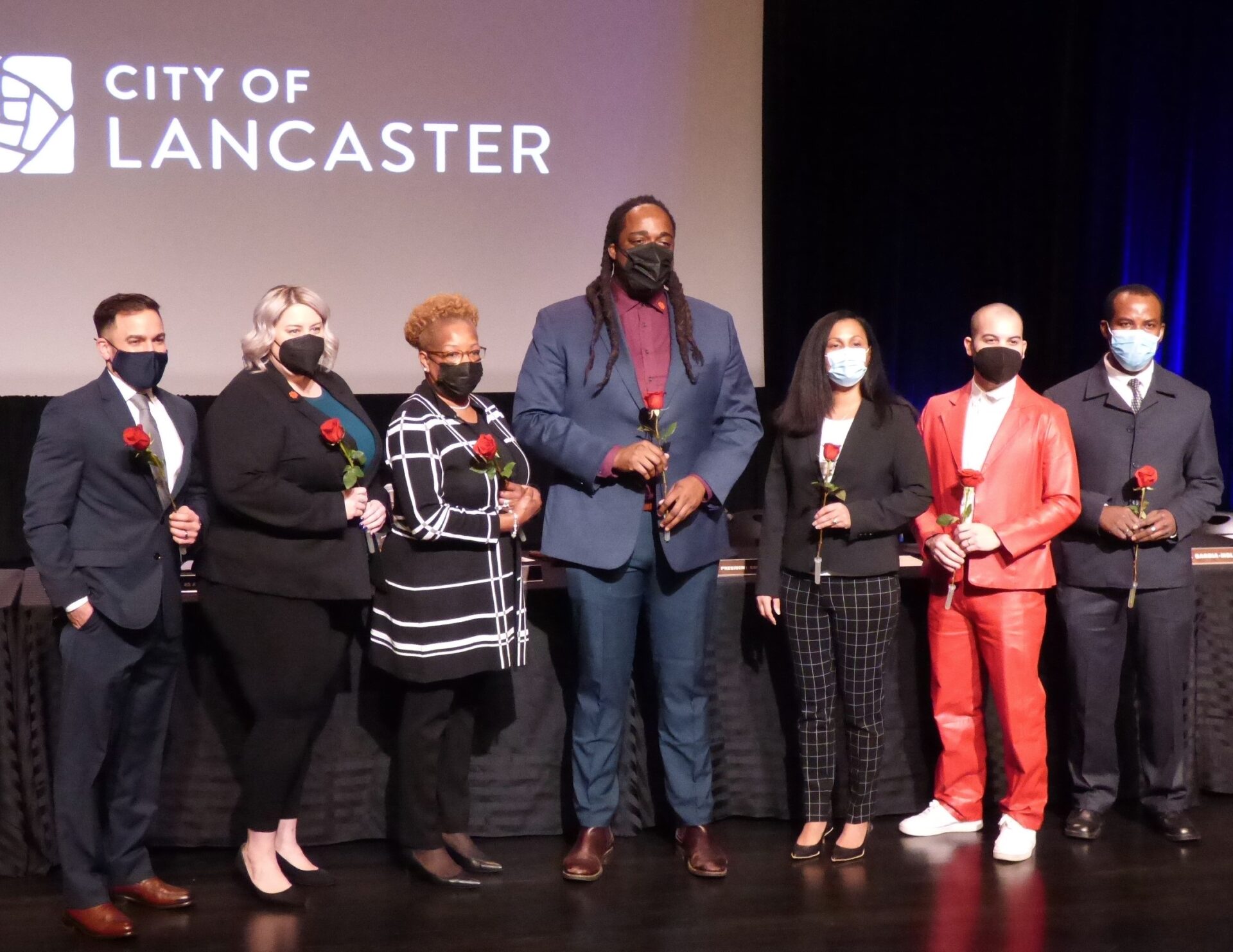 City Council members pose with red roses following the inaugural ceremonies and organizational meeting. From left: Jaime Arroyo, Amanda Bakay, Faith Craig, Ismail Smith-Wade-El, Janet Diaz, Xavier Garcia-Molina, Lochard Calixte. (Photo: Tim Stuhldreher) 