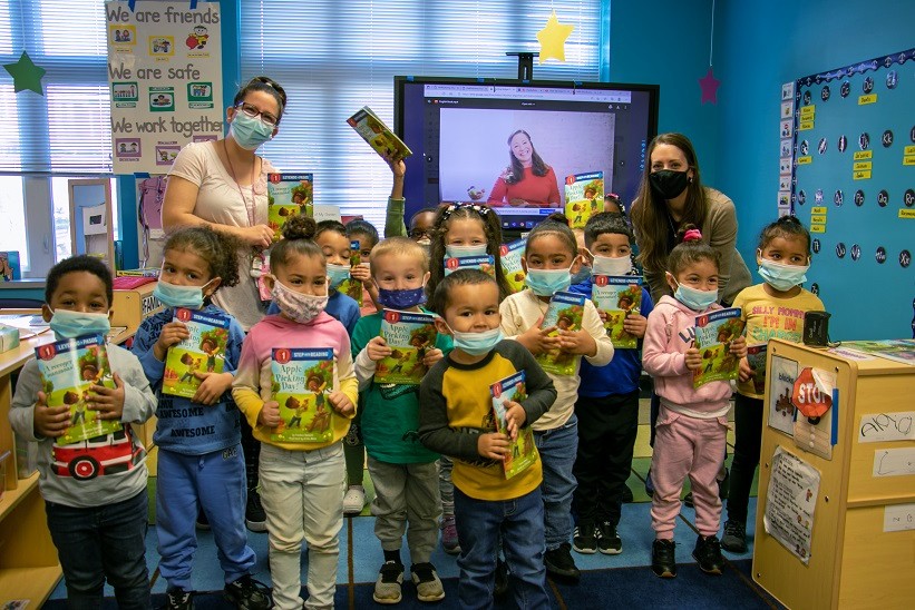 Teacher Evalise Kitch, left, and Ashley Little, instructional coach, right, join the children as they show off their copies of the book. (Photo: Brian Nguyen | CAP) 