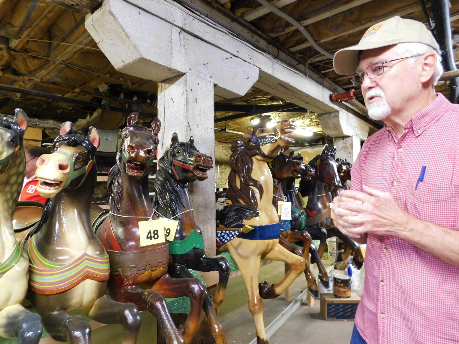 Carousel - main pic Tom Wolf, former owner and caretaker of the Rocky Springs Carousel, tells a story about one of the horses to his left. (Photo: Olivia Smucker)