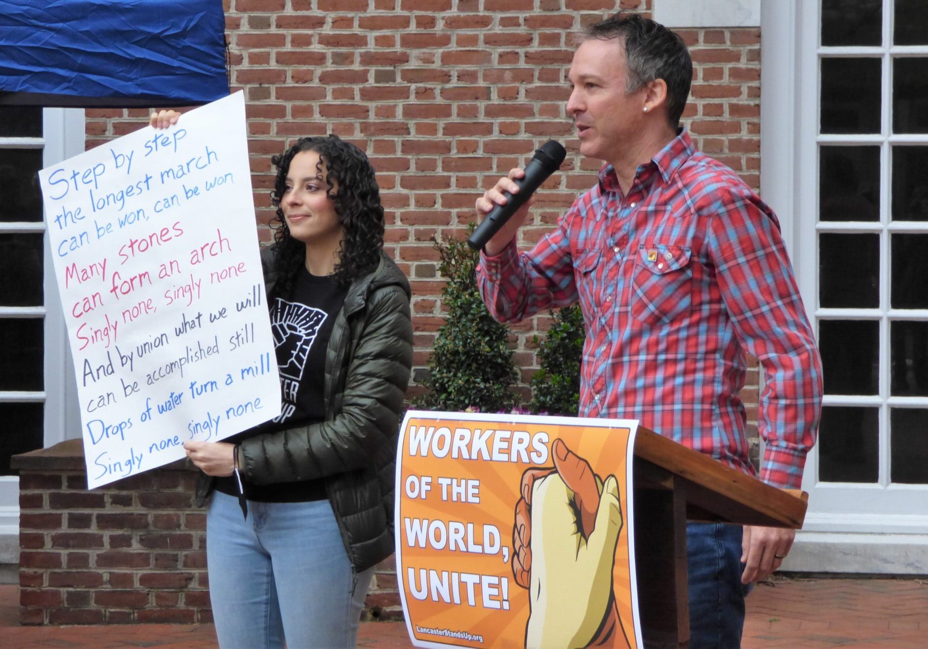 May Day 2 Lancaster Stands Up co-founder Jonathan Smucker, right, leads a song as organizer Suzy Wurtz holds up the lyrics during a May Day rally in Penn Square, Lancaster, on Sunday, May 1, 2022. (Photo: Tim Stuhldreher)